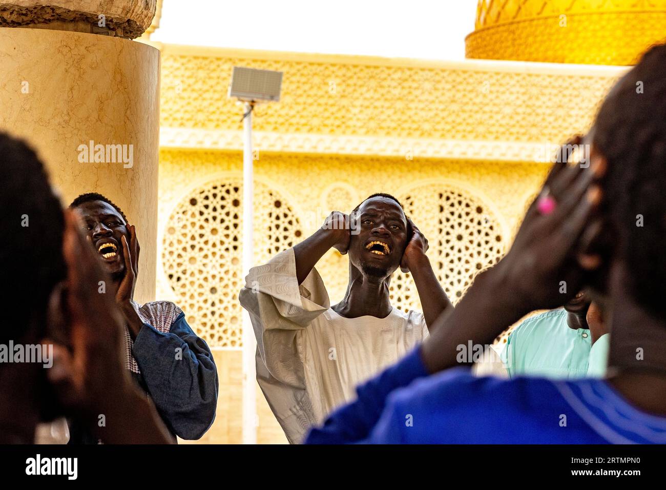 Des dévots chantant des vers coraniques dans la grande mosquée de Touba, Sénégal Banque D'Images