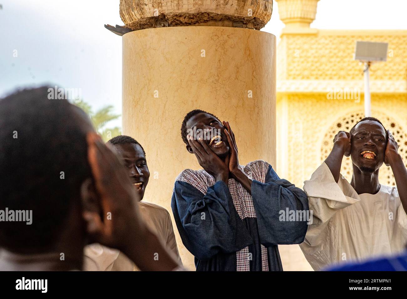 Des dévots chantant des vers coraniques dans la grande mosquée de Touba, Sénégal Banque D'Images
