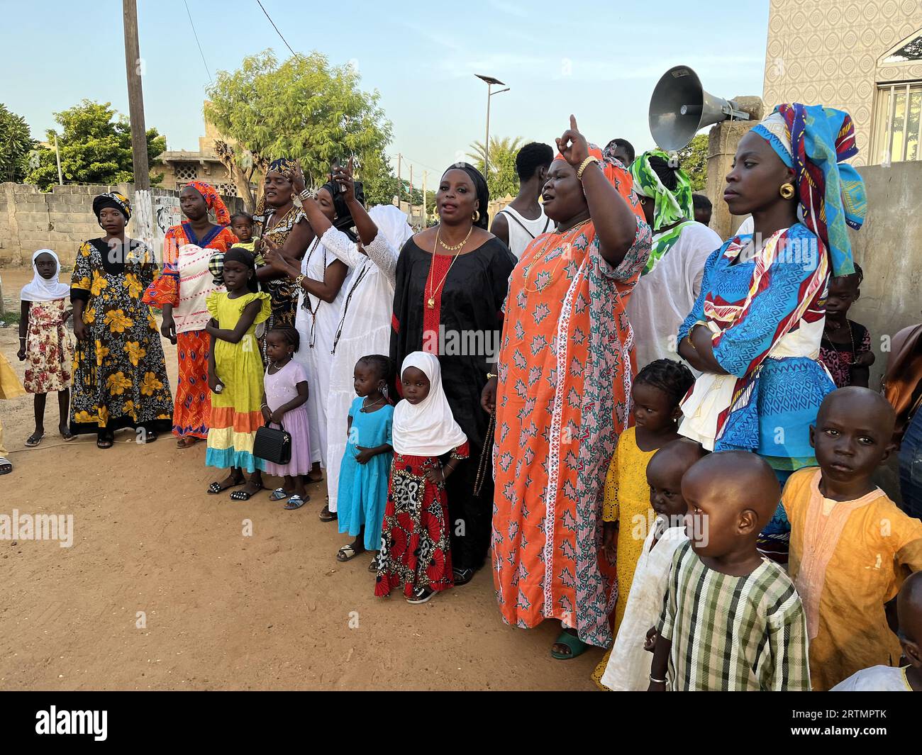 Des femmes et des enfants écoutant des musiciens et chantant devant une mosquée à Ndayane, au Sénégal Banque D'Images