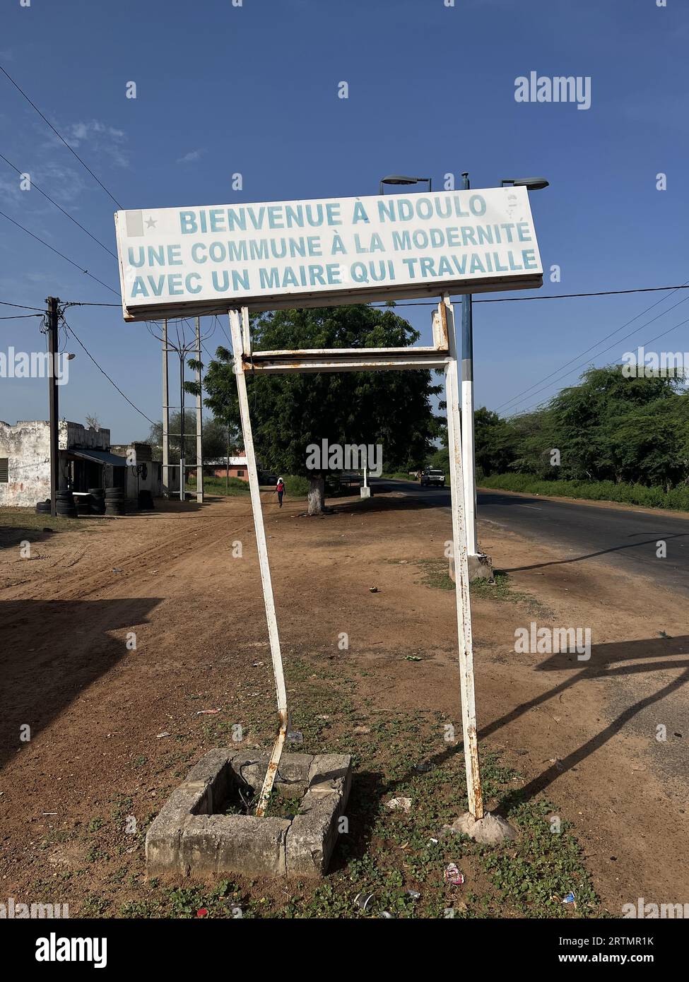 Panneau à l'entrée d'un village du centre du Sénégal : Bienvenue à Ndoulo, ville moderne dont le maire travaille Banque D'Images