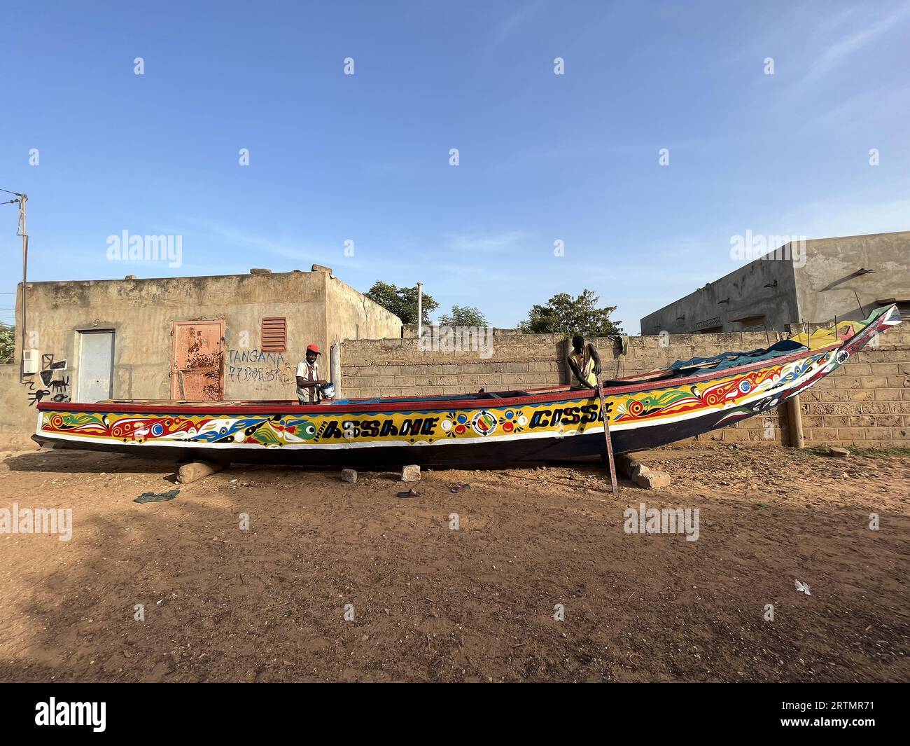 Des pêcheurs peignent leur bateau à Ndayane, au Sénégal Banque D'Images