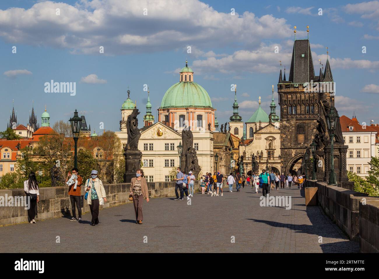 PRAGUE, TCHÉQUIE - 27 AVRIL 2020 : des personnes portant un masque traversent le pont Charles à Prague pendant le confinement du COVID-19 en République tchèque. Banque D'Images