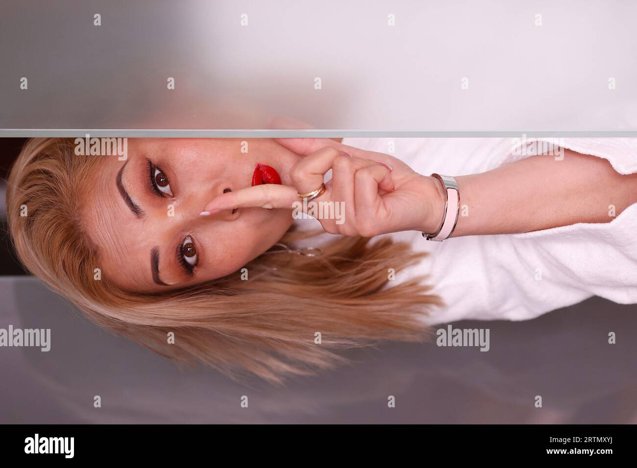 Femme regardant la caméra avec un doigt sur ses lèvres, demandant le calme, le silence ou le secret. Banque D'Images