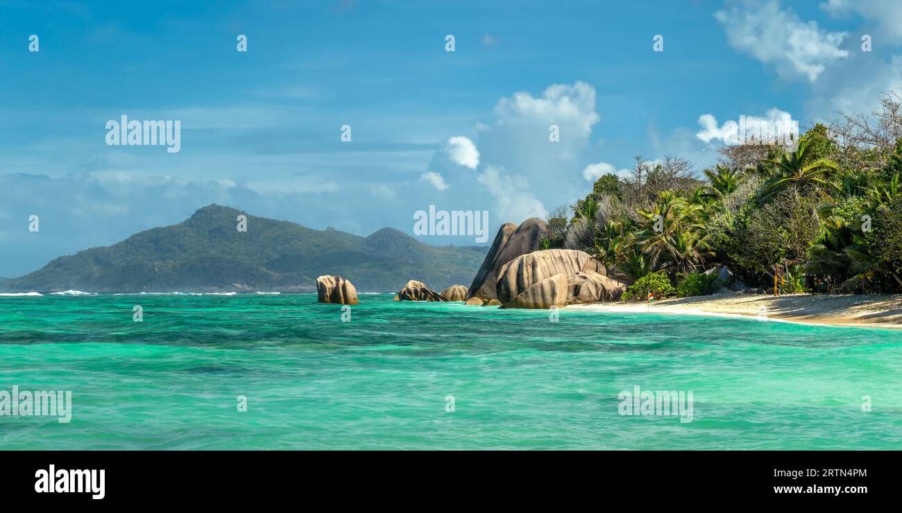 Roches granitiques et palmiers sur la pittoresque plage de sable tropical Anse Source d'argent, île de la Digue, Seychelles Banque D'Images
