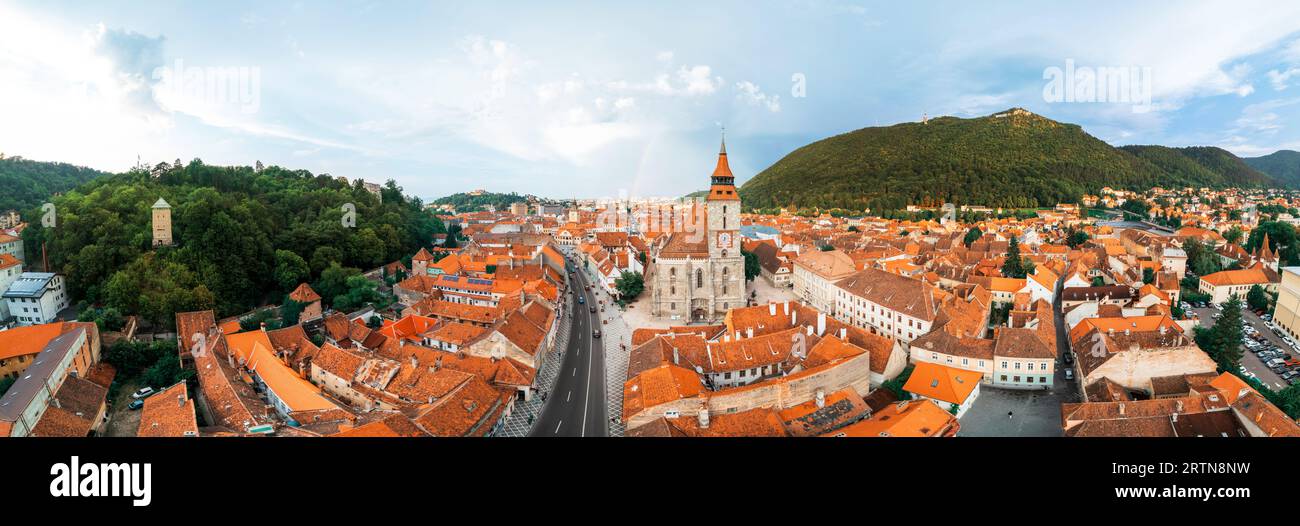 Drone aérien vue panoramique de l'église Noire dans le vieux centre de Brasov, Roumanie. Vieux bâtiments résidentiels autour d'elle, rues étroites avec voiture en mouvement Banque D'Images