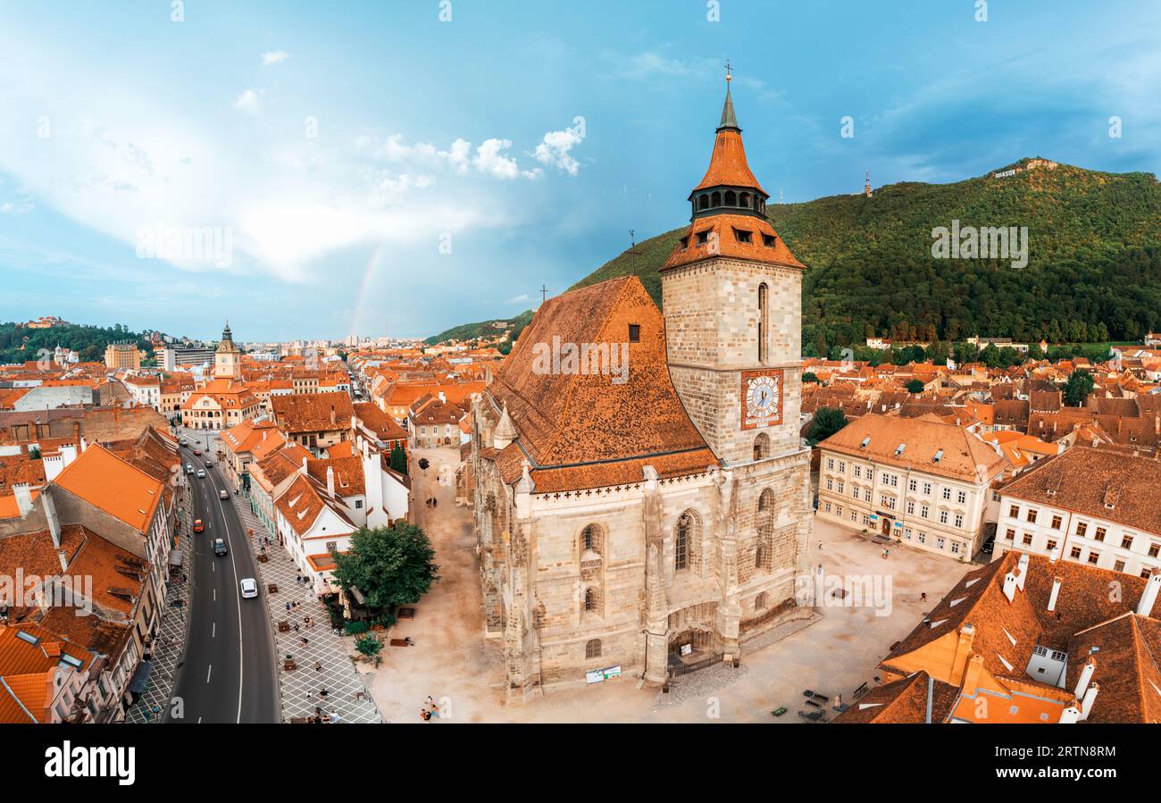 Drone aérien vue panoramique de l'église Noire dans le vieux centre de Brasov, Roumanie. Vieux bâtiments résidentiels autour d'elle, rues étroites avec voiture en mouvement Banque D'Images
