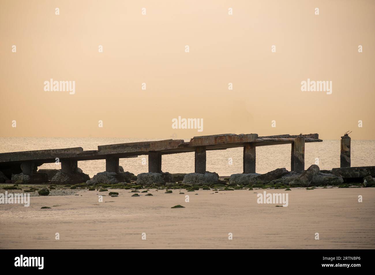 Long pont maritime cassé pour regarder le lever du soleil - coucher du soleil et la pêche. Pont maritime brisé avec des vagues de la mer pendant le matin avec un ton chaud. Calme et paix Banque D'Images