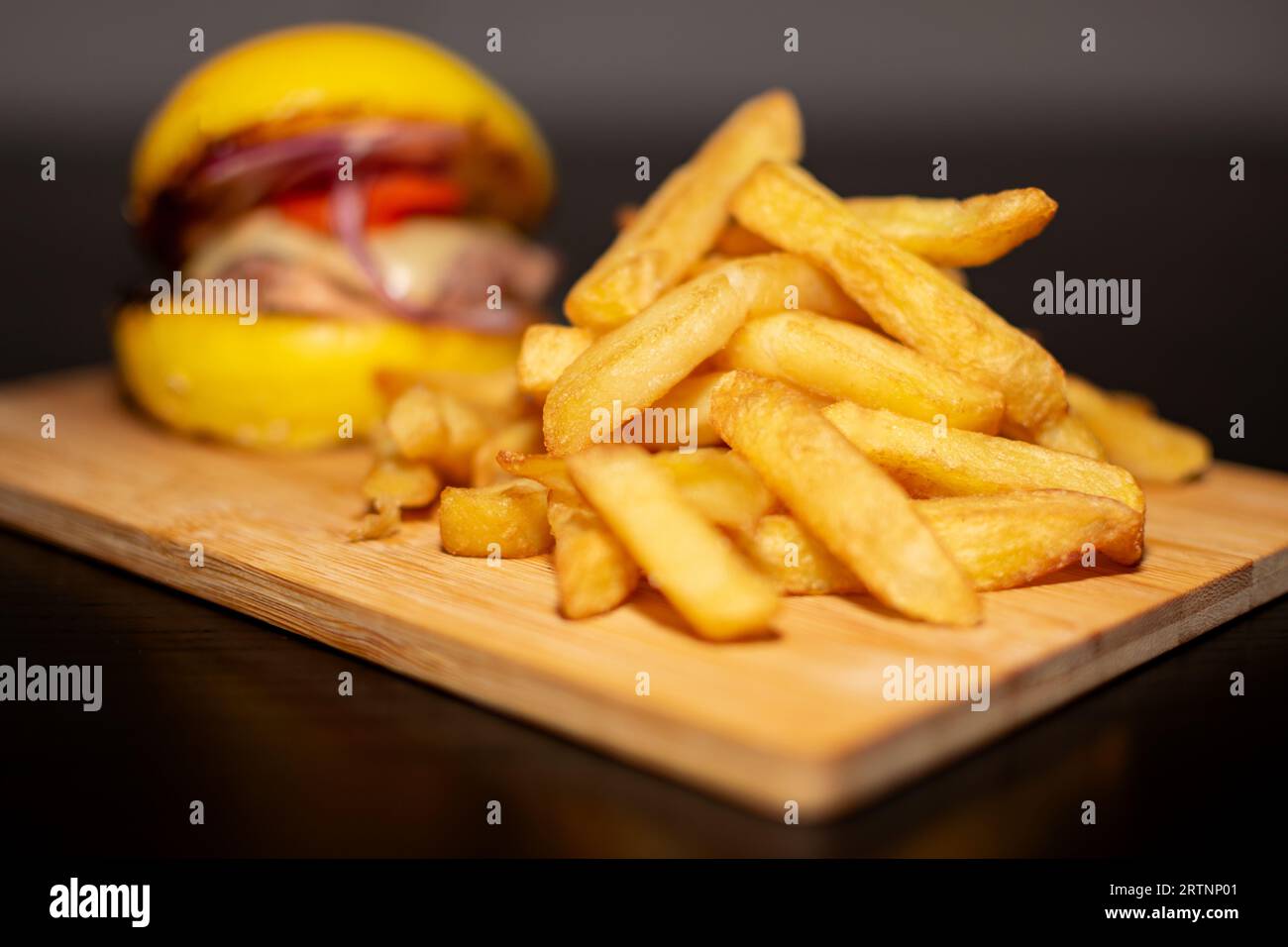 Hamburger jaune Mini Gourmet avec frites sur planche de bois Banque D'Images