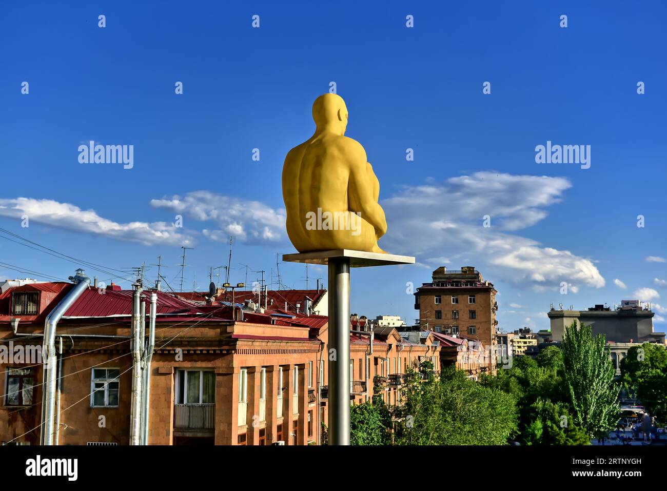 Statue de lanterne d'art moderne d'un homme jaune assis en méditation regardant vers l'horizon d'Erevan dans le complexe Cascade à Erevan, Arménie Banque D'Images