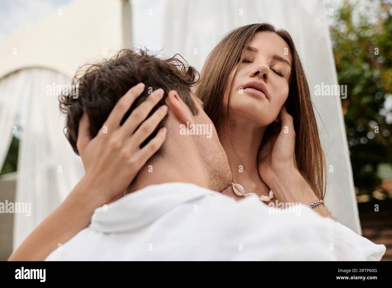 portrait d'homme embrassant le cou de belle femme lors d'une escapade romantique en été, geste d'amour Banque D'Images