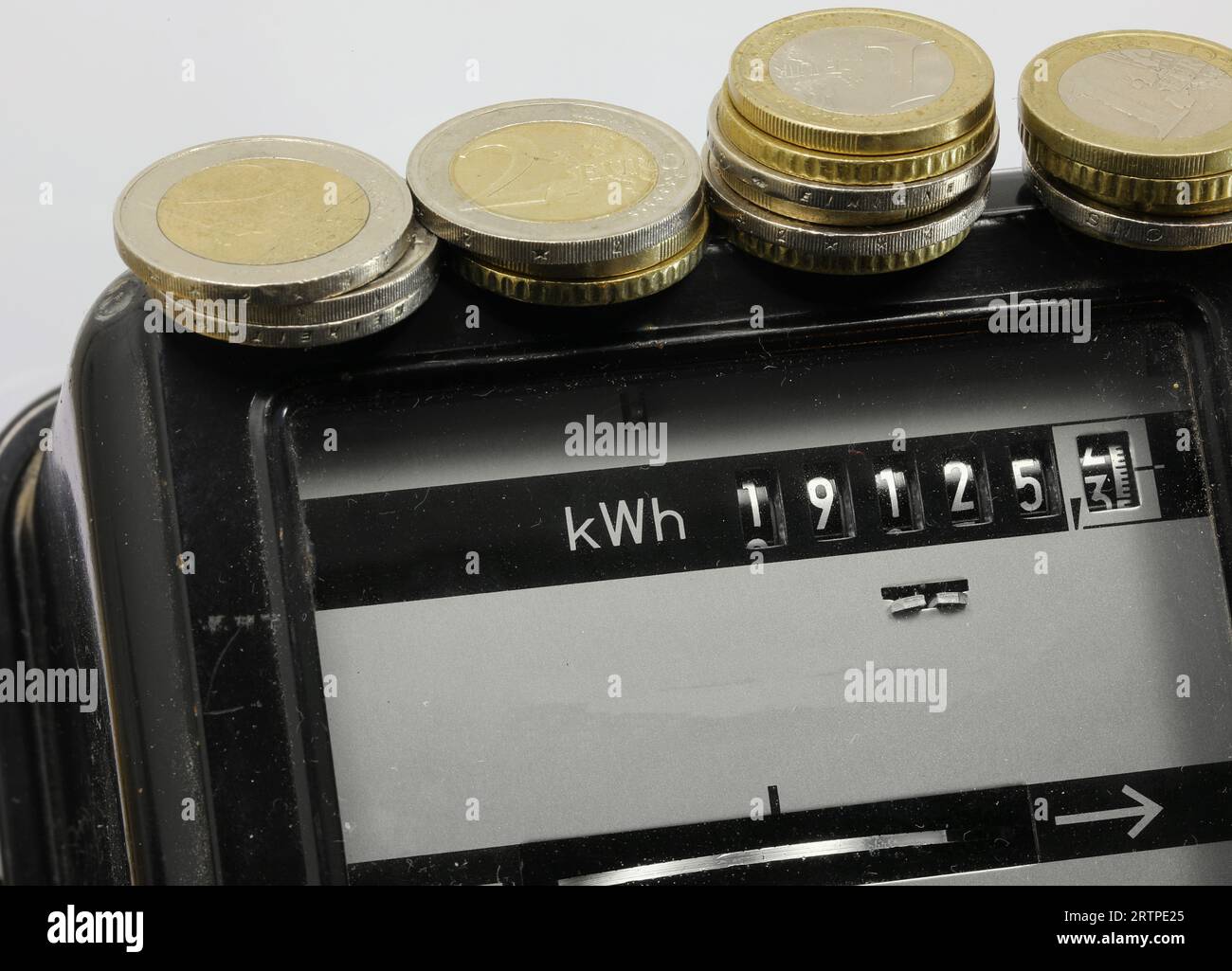 Compteur d'électricité avec la valeur en kWh et pièces en euros dessus Banque D'Images