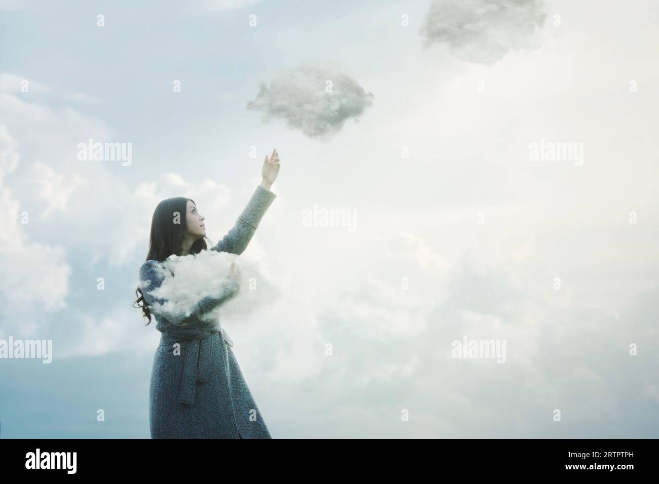 femme surréaliste libère les nuages qu'elle tenait dans ses bras dans le ciel, concept abstrait Banque D'Images