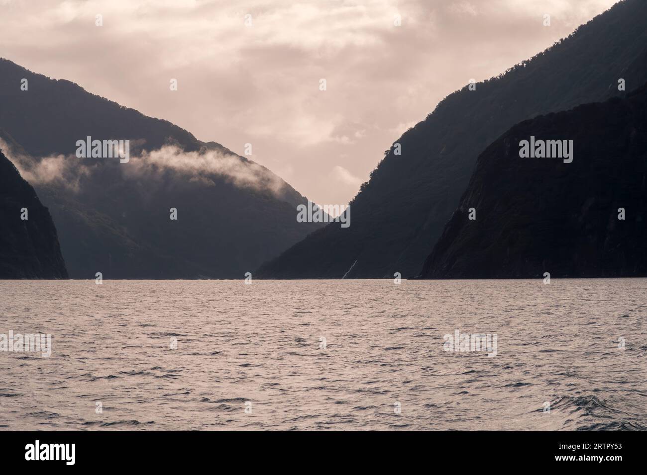 Photographie de nuages bas suspendus au-dessus des montagnes dans Milford Sound dans le parc national de Fiordland sur l'île du Sud de la Nouvelle-Zélande Banque D'Images