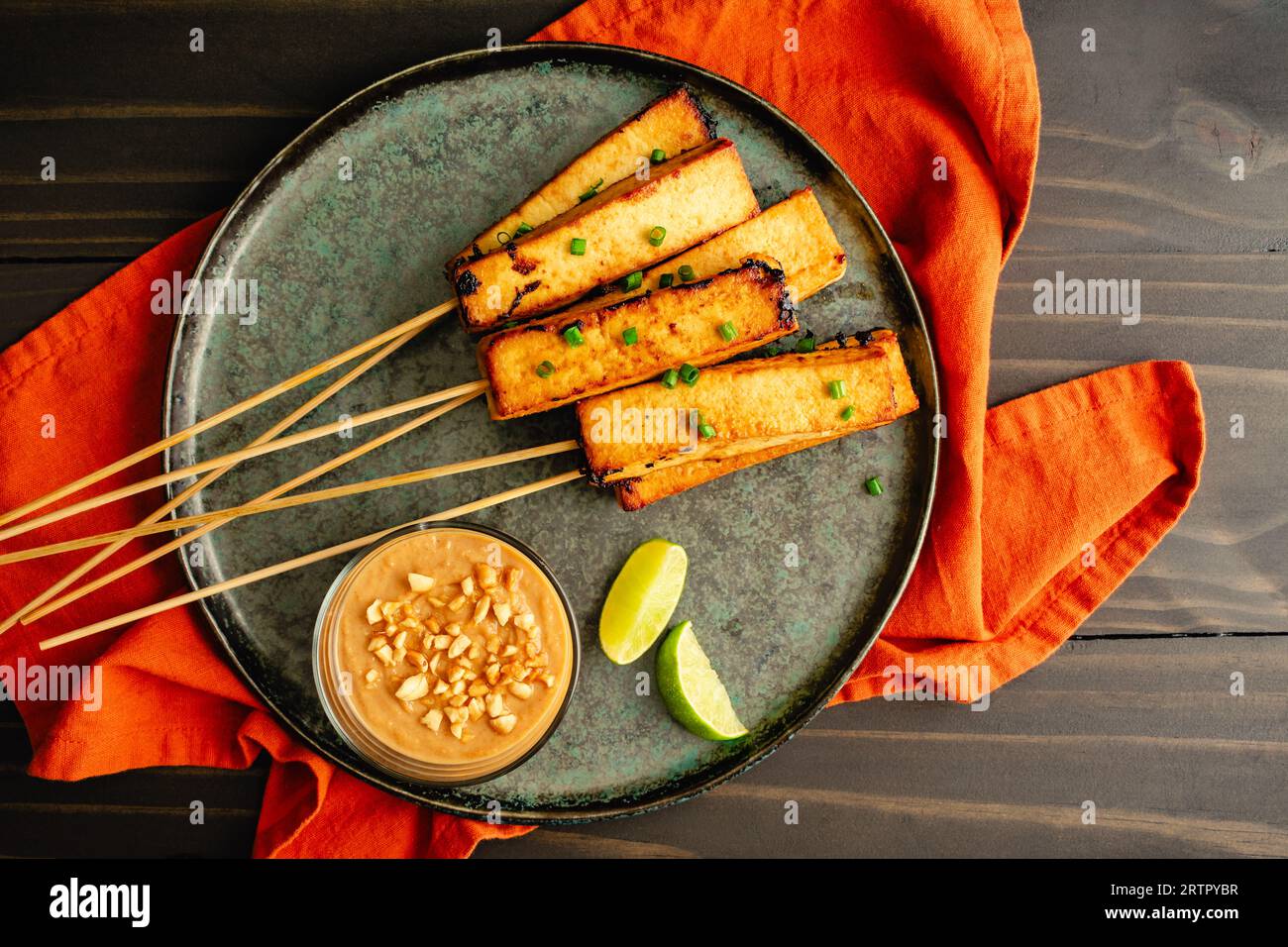 Tofu végétalien Satay avec sauce arachide : Tofu mariné servi sur des brochettes de bambou avec sauce arachide et quartiers de citron vert Banque D'Images