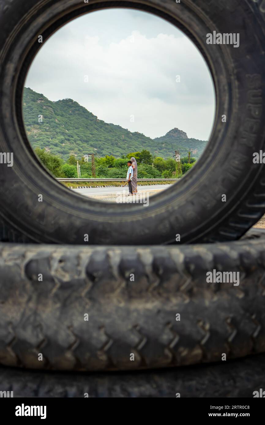 Un garçon du village et sa mère attendent pour le transport à l'autoroute le matin, vu d'une perspective unique image est prise à ajmer rajasthan inde Banque D'Images