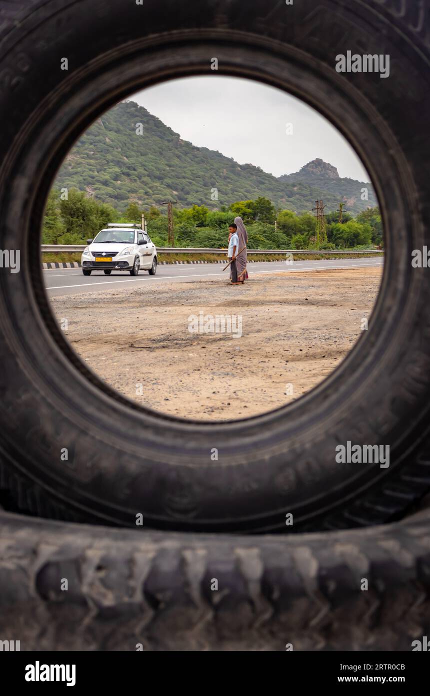 Un garçon du village et sa mère attendent pour le transport à l'autoroute le matin, vu d'une perspective unique image est prise à ajmer rajasthan inde Banque D'Images