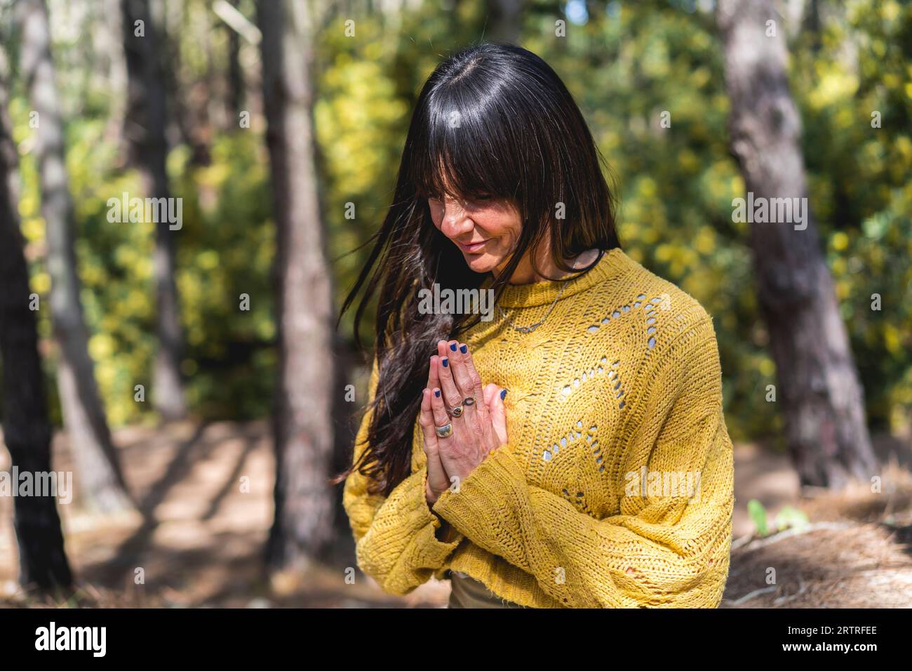 Femme médite avec les mains serrées sur les bois. Banque D'Images