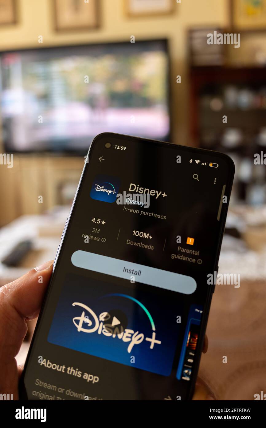 Madrid, Espagne : 09 12 2023 : main tenant un smartphone avec l'application Disney + Banque D'Images