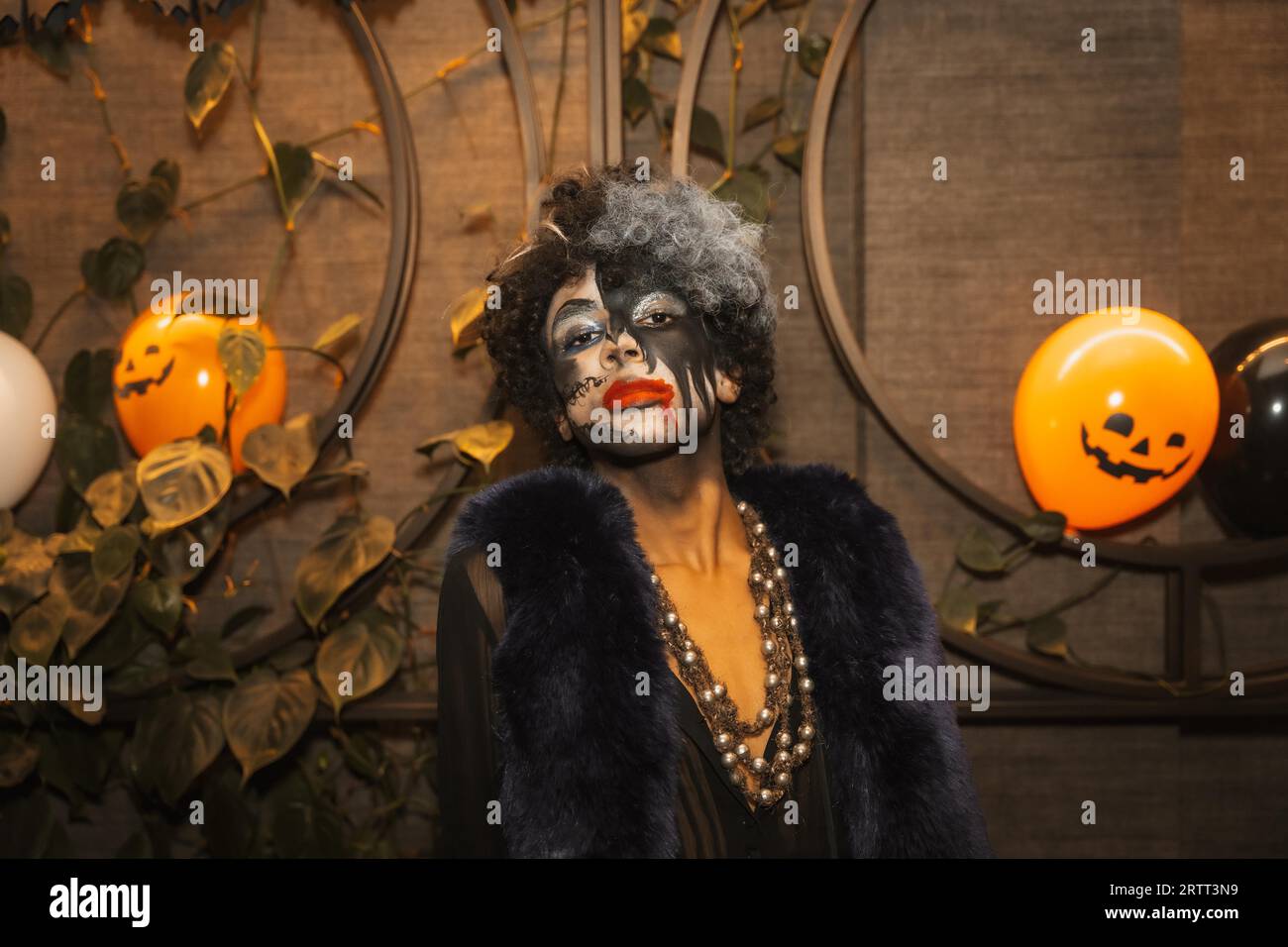 Fête d'Halloween avec des amis dans une discothèque, portrait d'un homme en maquillage noir et blanc Banque D'Images