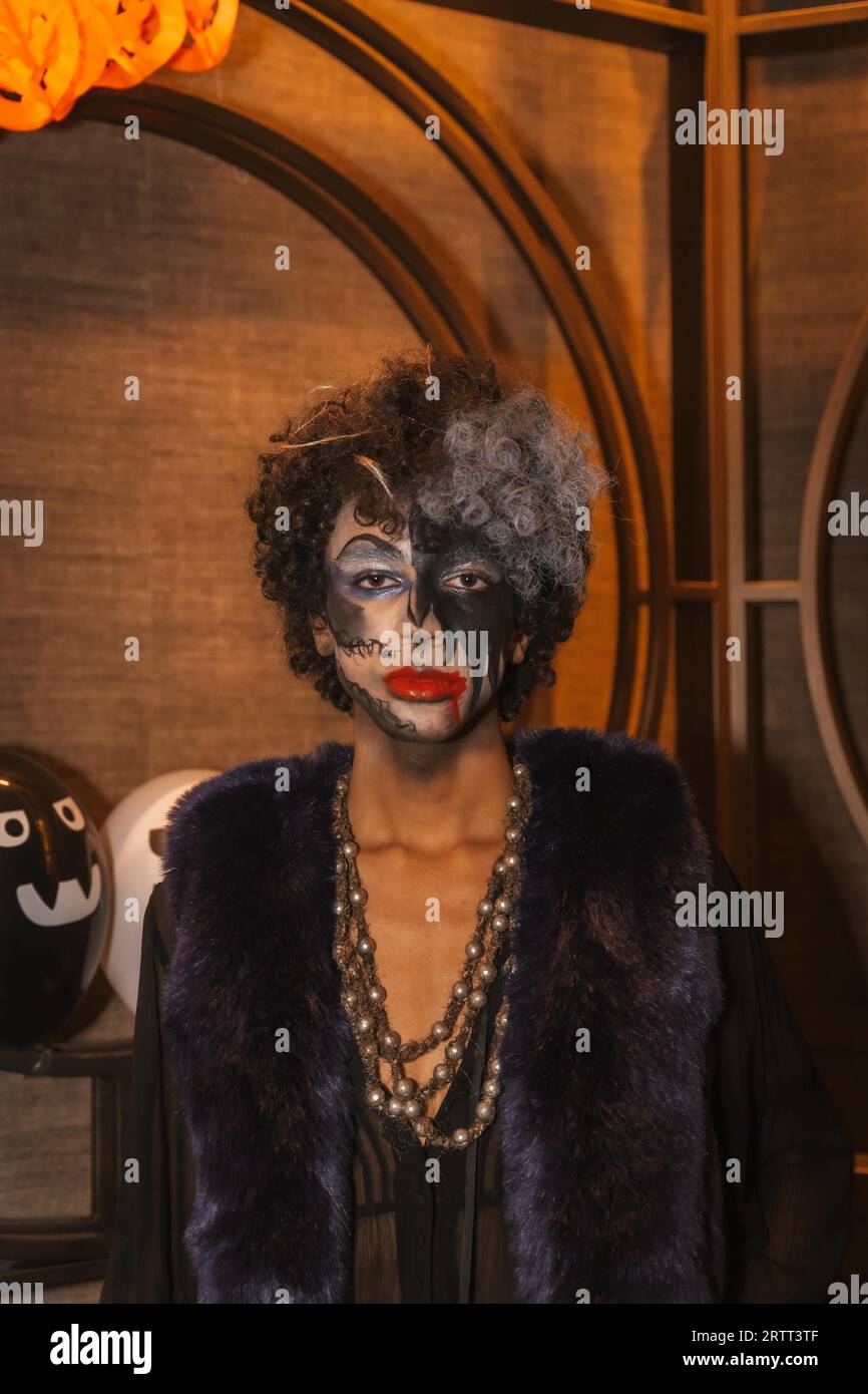 Fête d'Halloween avec des amis dans une discothèque, portrait d'un homme avec son visage peint en noir et blanc Banque D'Images