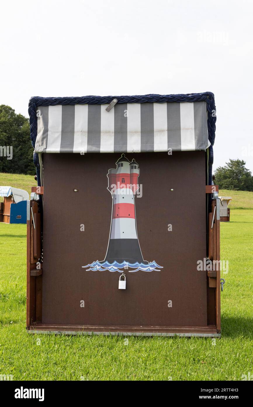 Chaise de plage avec peinture de phare sur une prairie verte à la plage de Cuxhaven, côte de la mer du Nord, Basse-Saxe, Allemagne Banque D'Images