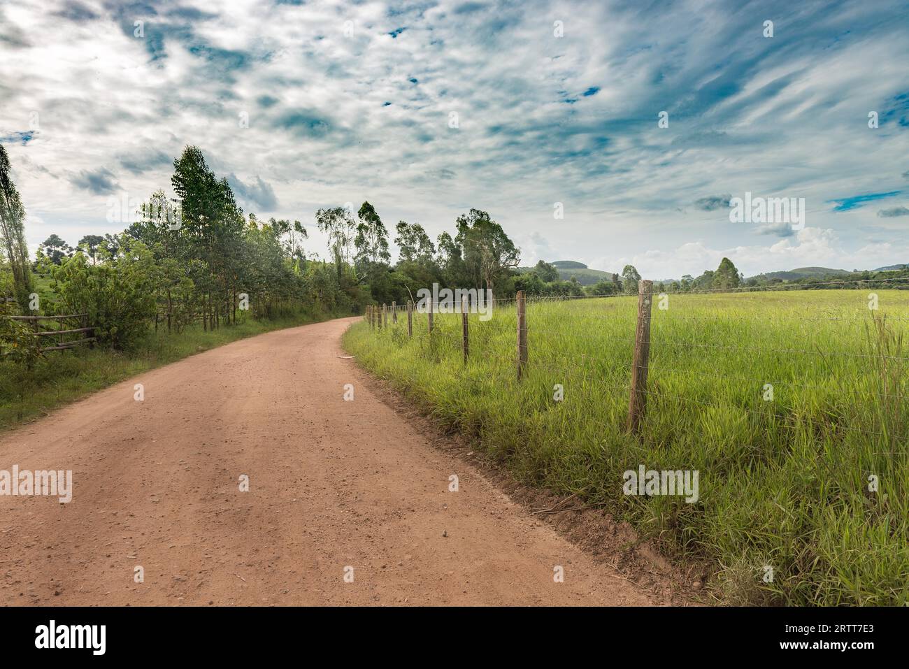 Chemin de terre et barbelés sur l'après-midi d'été dans les montagnes de Minas Gerais, Brésil Banque D'Images