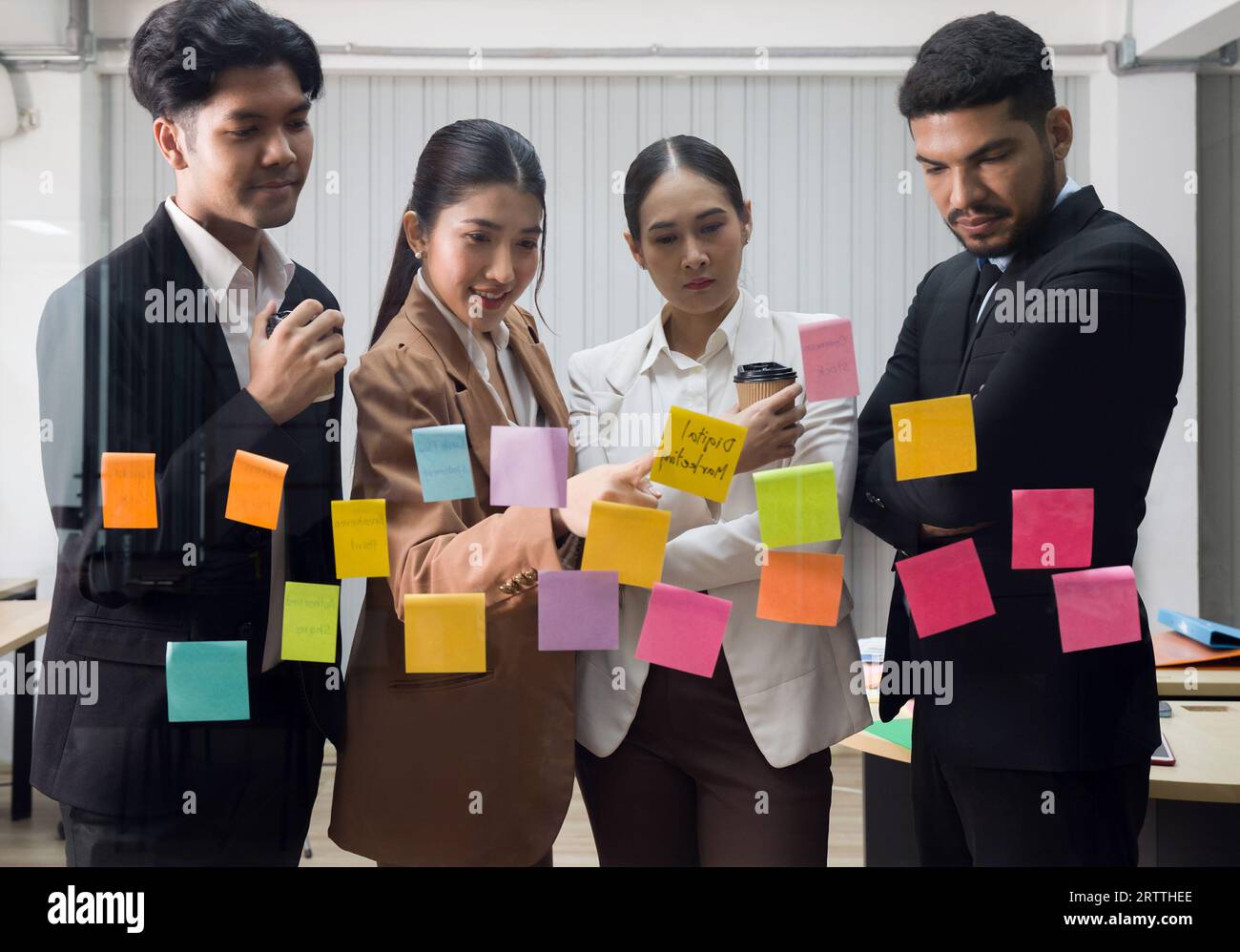 Groupe de gens d'affaires en réunion avec des notes de papier adhésif sur le mur de verre pour de nouvelles idées. Utiliser une méthodologie agile pour les entreprises dans un début technologique Banque D'Images