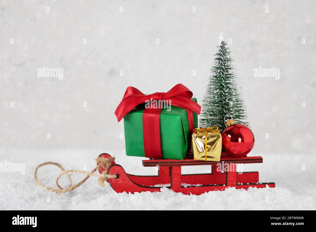 Luge miniature avec cadeaux de Noël, ornement et arbre de Noël. Joyeux Noël et bonne année carte de voeux. Banque D'Images