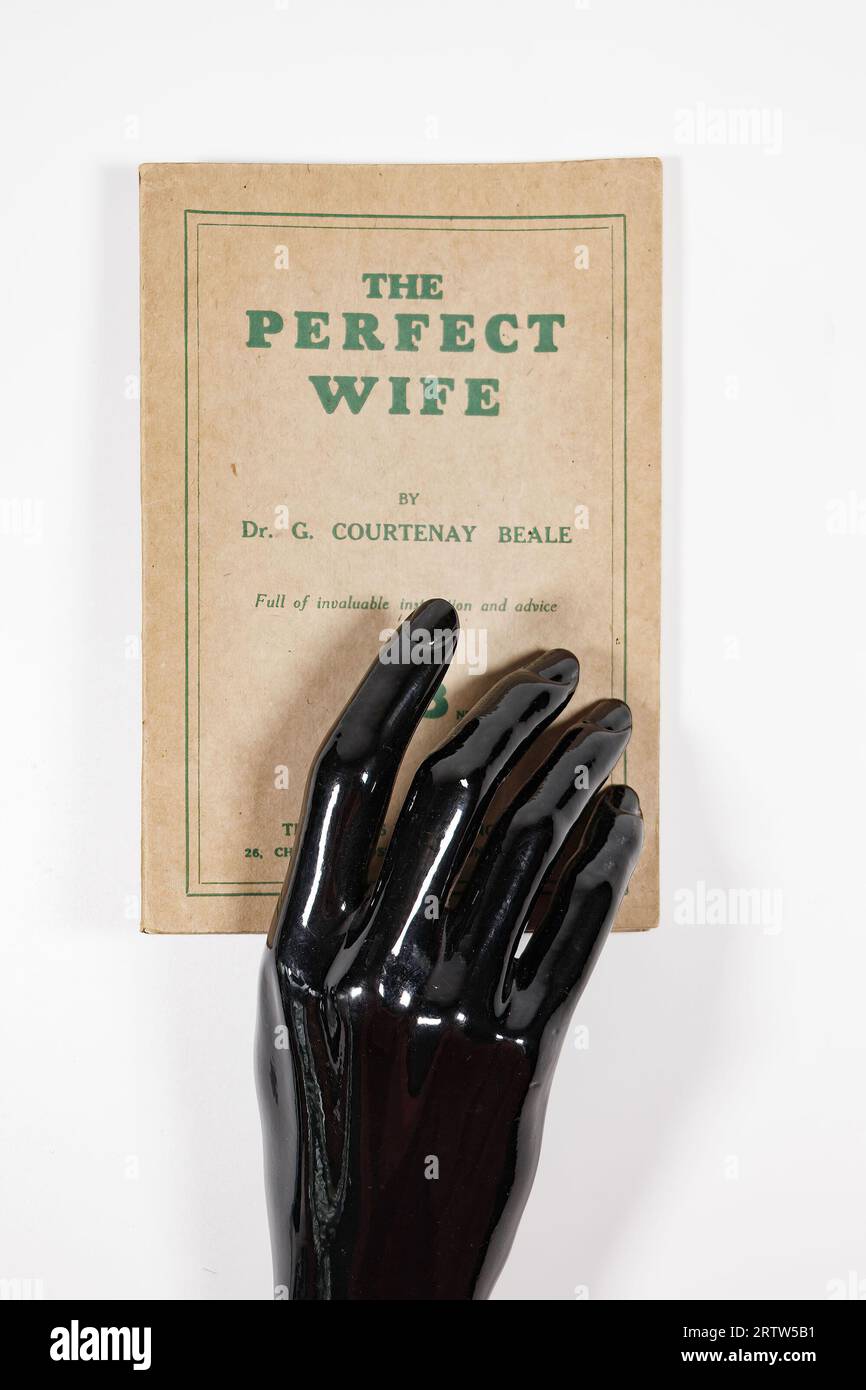 Livre vintage The Perfect Wife par Dr G Courtenay Beale isolé contre un fond blanc studio maison d'édition wales - brillant noir mannekin Hands Banque D'Images