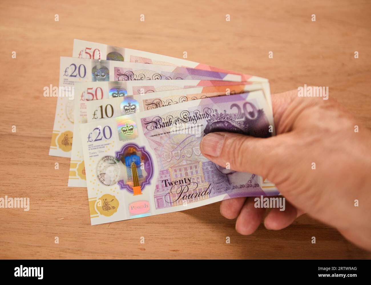 Tenant des billets en livre sterling Banque D'Images