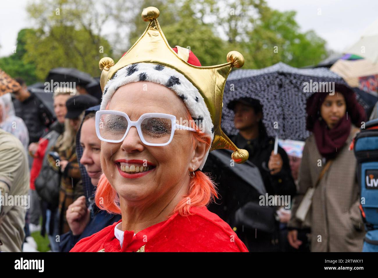 Une foule nombreuse bravant la pluie pour regarder le couronnement du roi Charles III, sur un écran géant. Hyde Park, Londres, Royaume-Uni. 6 mai 2023 Banque D'Images