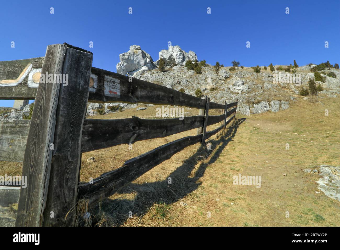 Sentier de randonnée marquant sur une ancienne clôture en bois, prairie verte entourée d'une clôture en bois Banque D'Images