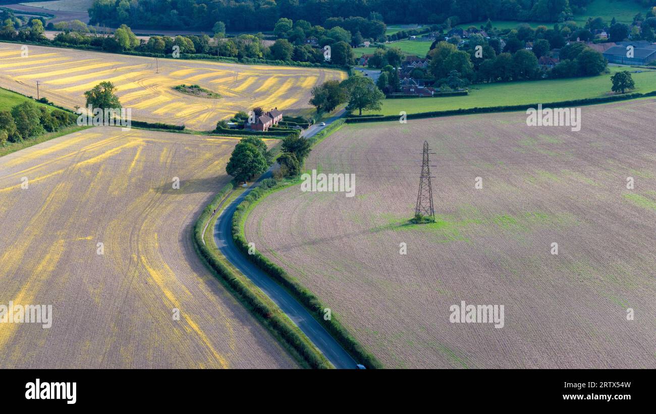 Paysage aérien de la campagne près du village de West Compton dans le West Sussex. Pylônes électriques traversant la terre. Route au milieu de la prise de vue Banque D'Images