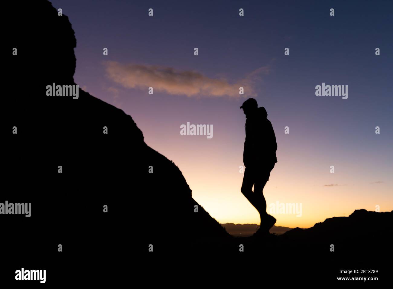 Jeune homme sur une randonnée au lever du soleil en silhouette Banque D'Images