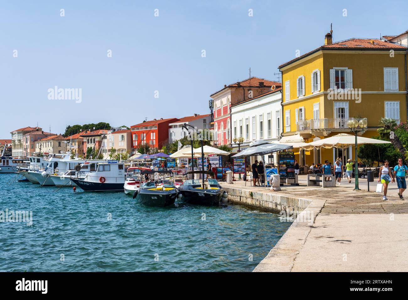Bâtiments colorés et bateaux sur les quais de Poreč, une station balnéaire populaire, sur la péninsule d'Istrie en Croatie Banque D'Images