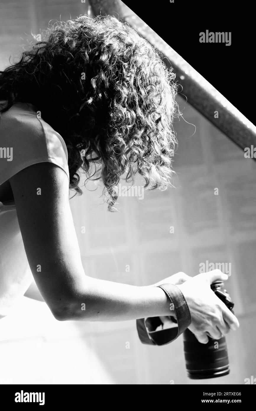 Profesional femme photographe tenant l'appareil photo et prenant des photos. Banque D'Images