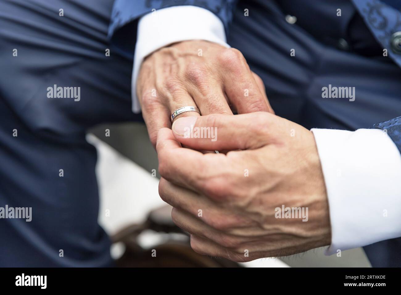Gros plan des mains d'homme d'élégance avec anneau. Photo recadrée d'un époux méconnaissable ajustant sa bague le jour de son mariage. Banque D'Images