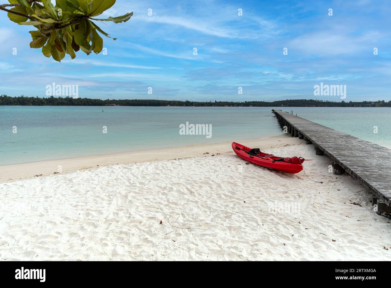 Canoë rouge et jetée en bois sur sable blanc ko kham , île de Koh Chang, Thaïlande. Banque D'Images