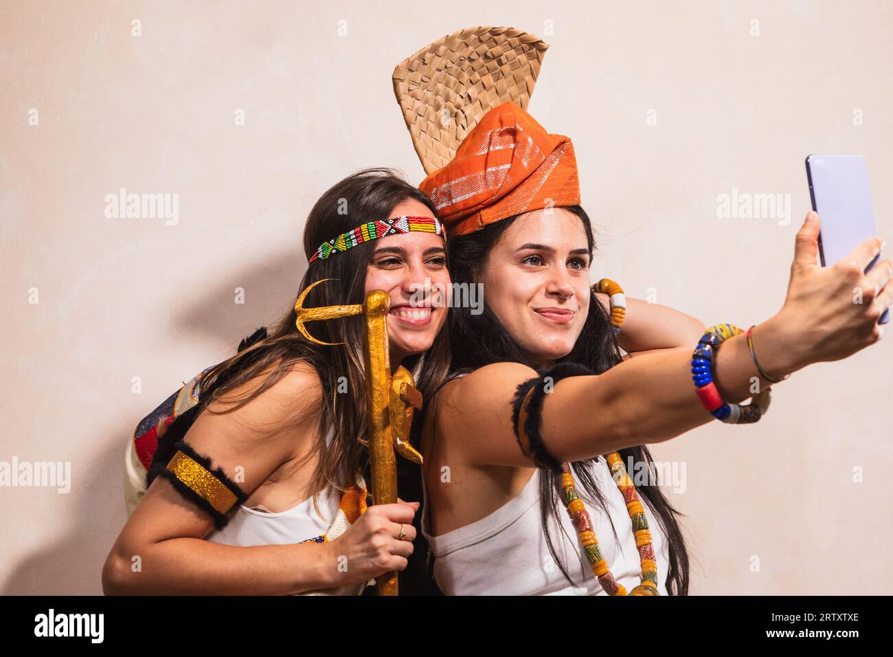 Couple de filles sympathiques prenant un selfie portant des vêtements ethniques de la culture africaine. Accessoires et mode typiquement africaine. Photographie drôle pour soc Banque D'Images