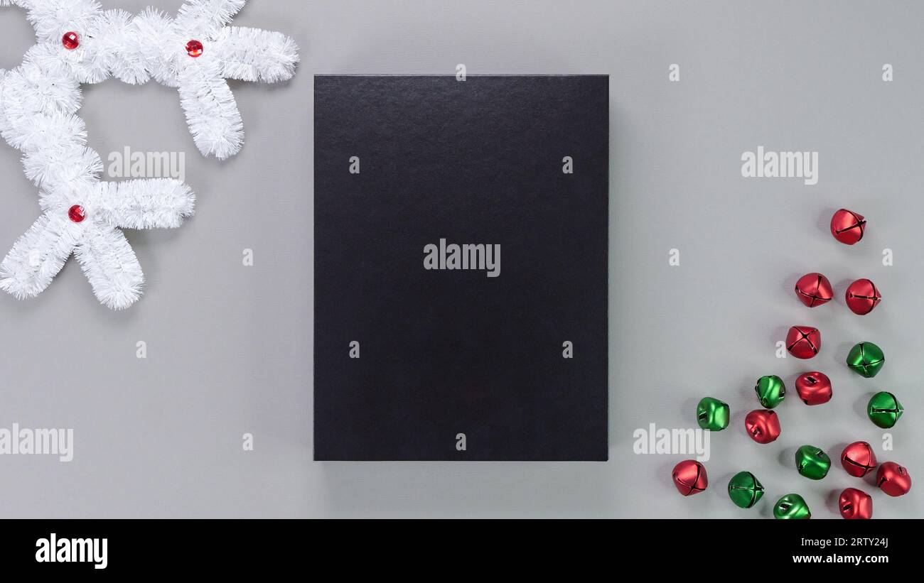 Composition de modèle avec boîte noire vierge, boîte cadeau, emballage de produit sur fond gris avec décor de vacances. Maquette, carte photo, carte de Noël, gre Banque D'Images