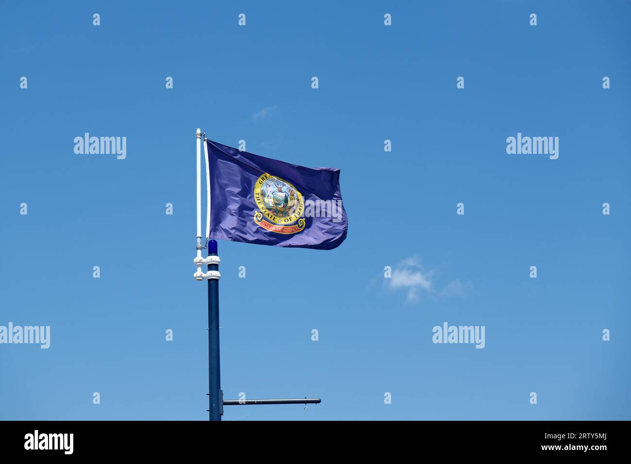 Gros plan du drapeau de l'État de l'Idaho sur un fond de ciel bleu et des nuages blancs Banque D'Images