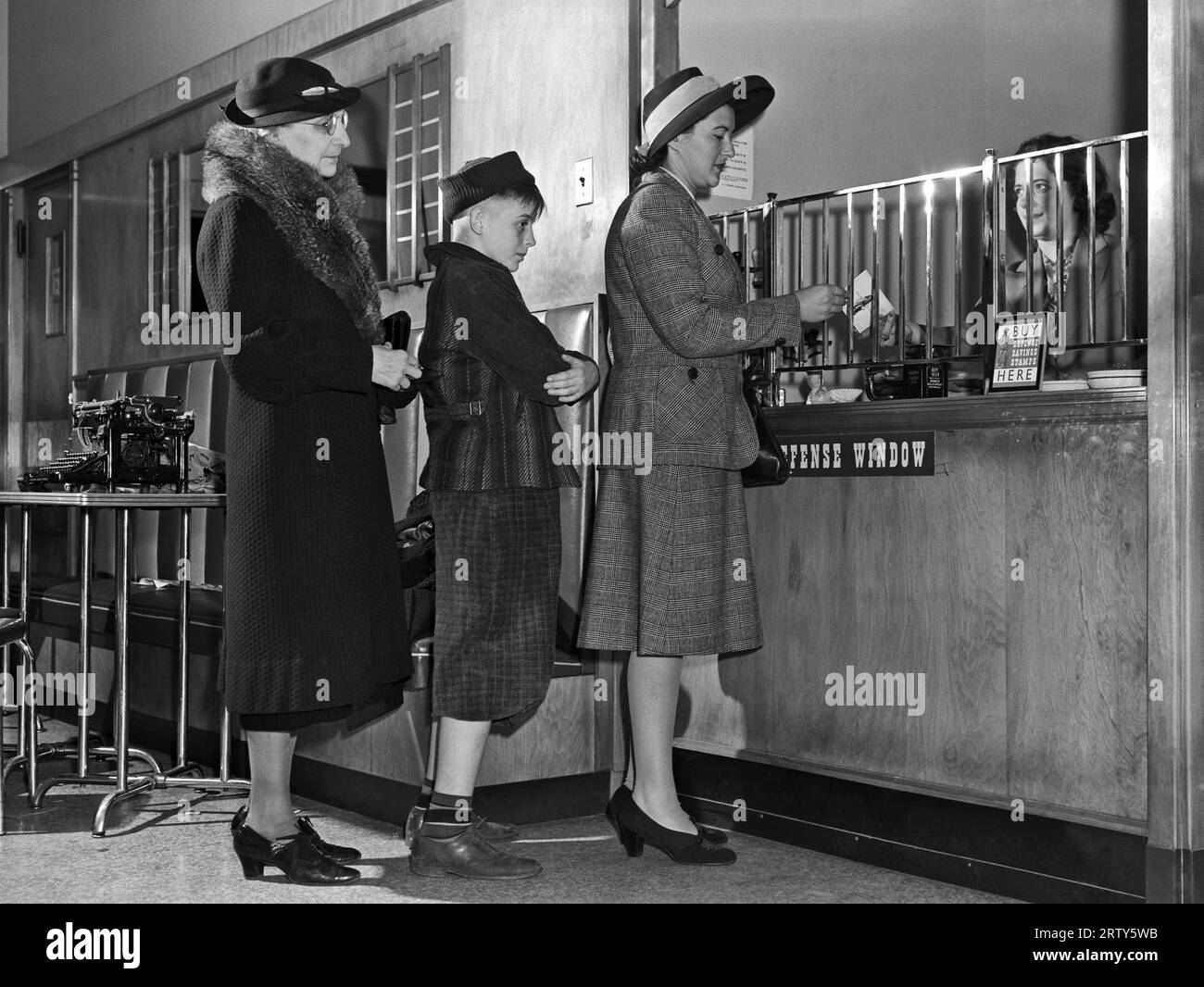 États-Unis 1942 les femmes s'alignent pour acheter des obligations de défense pendant la Seconde Guerre mondiale Titre original : « pour l’assurance contre l’axe, achetez des obligations de défense et des timbres. Vous pouvez les obtenir à votre banque, bureau de poste, grand magasin et chez votre newsboy. » Photographie prise par Ann Rosener pour le Bureau de la gestion des urgences Banque D'Images