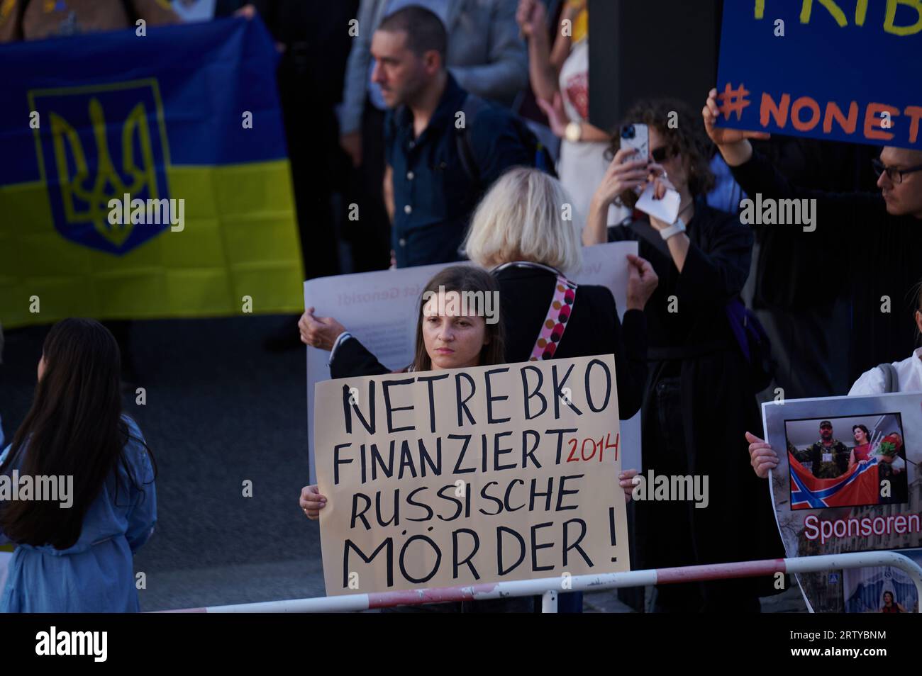 Berlin, Allemagne. 15 septembre 2023. "Netrebko finance des meurtriers russes !" Est écrit sur une affiche tenue par un démonstrateur devant le Staatsoper Unter den Linden. Une protestation contre la performance de Macbeth avec Netrebko est en cours. Les initiateurs accusent le chanteur russe de soutenir Poutine. Crédit : Annette Riedl/dpa/Alamy Live News Banque D'Images
