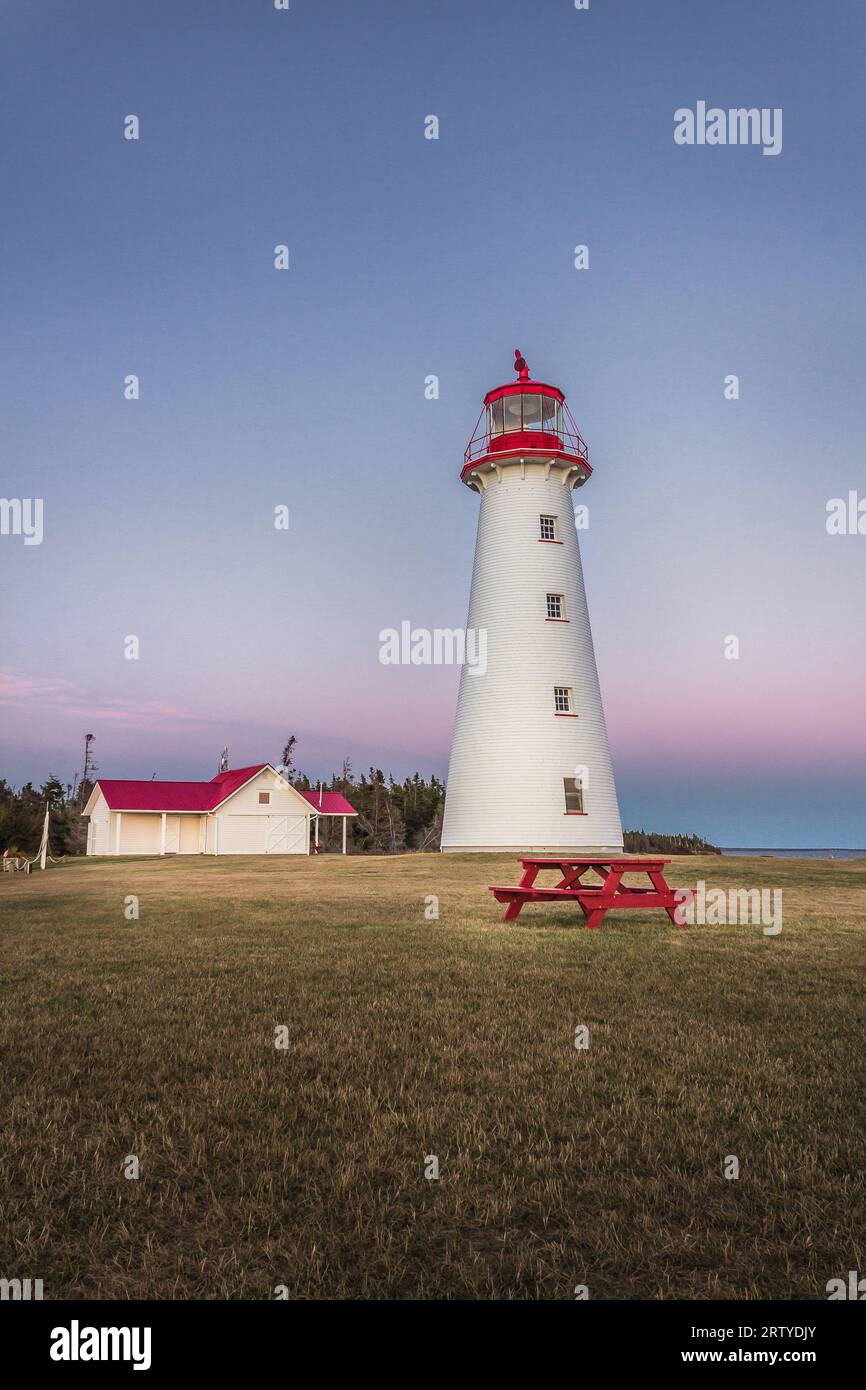 Phare de point Prim, Île-du-Prince-Édouard, Canada, pendant un coucher de soleil estival sans nuages. Banque D'Images