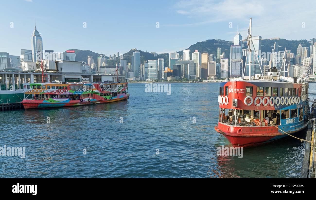 Deux vieux Star Ferries amarrés dans le port de Kowloon surplombant les gratte-ciel de Hong Kong par une journée ensoleillée. Hong Kong - 30 août 2023 Banque D'Images