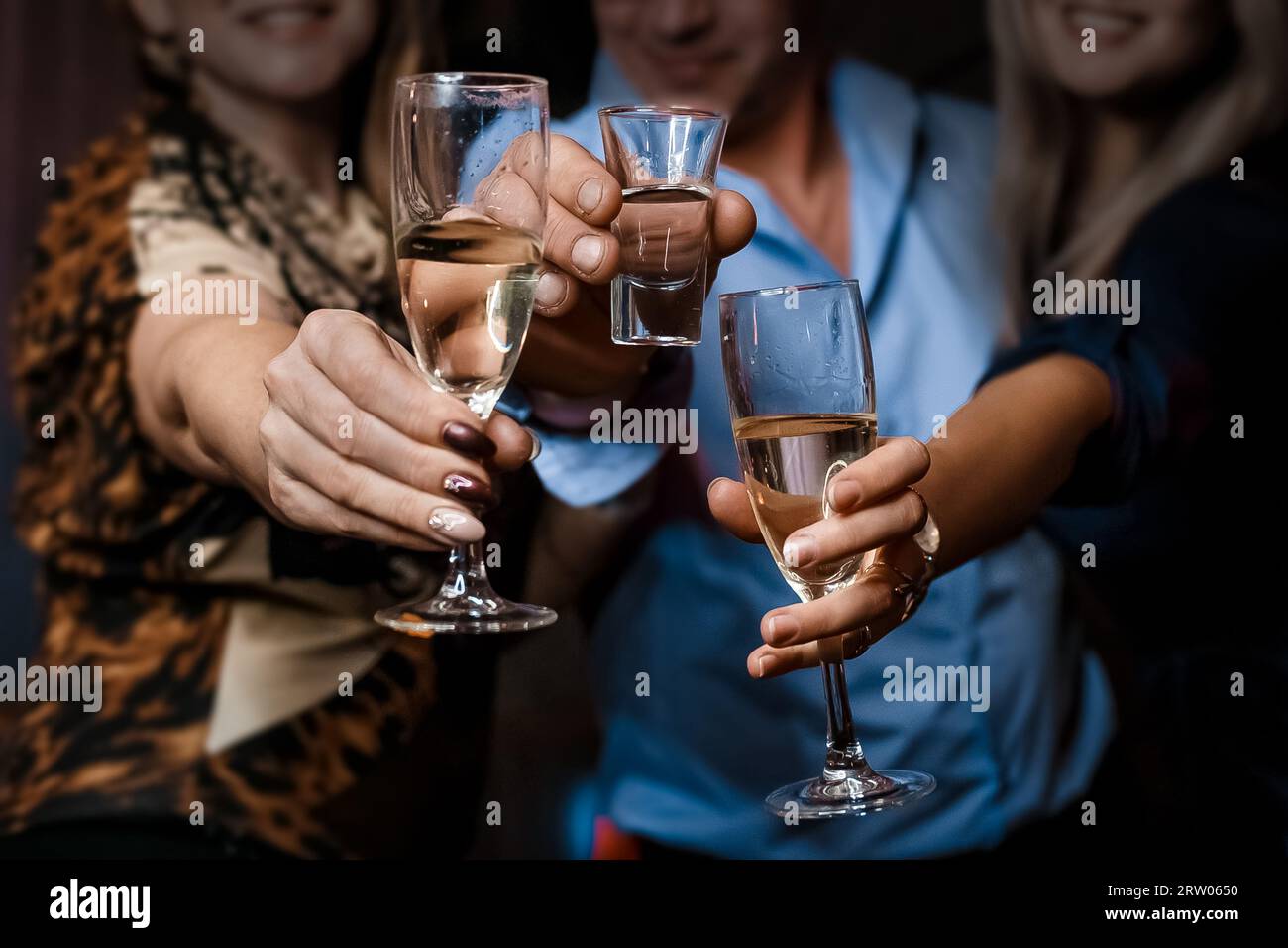 Mains de filles et d'hommes clinquant des lunettes et un verre d'alcool gros plan de la fête. Banque D'Images