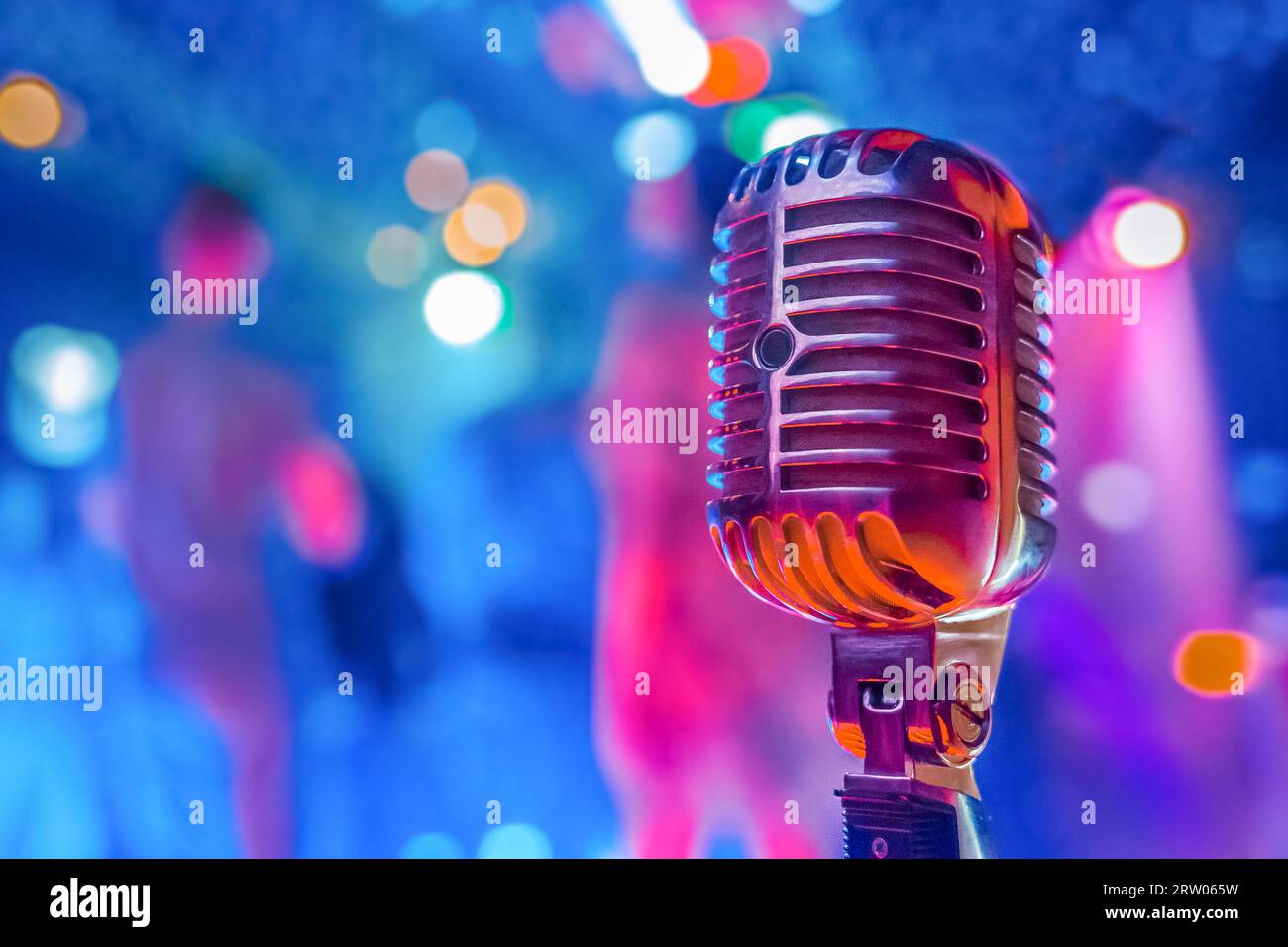 Microphone rétro professionnel gros plan dans une ambiance de club avec néon. Banque D'Images