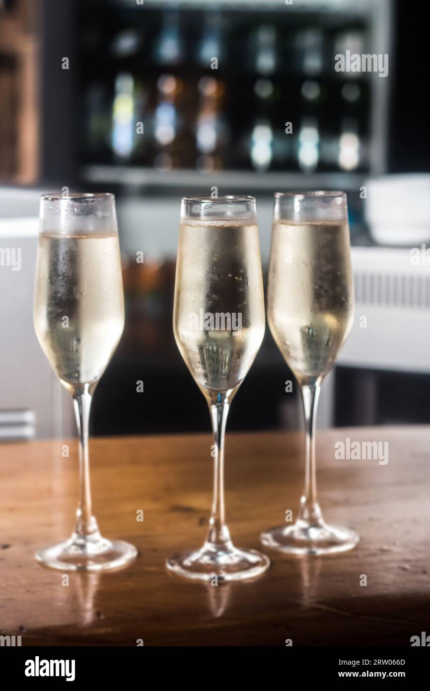 Alcool léger frais dans 3 verres de champagne sur le fond du comptoir de bar. Banque D'Images