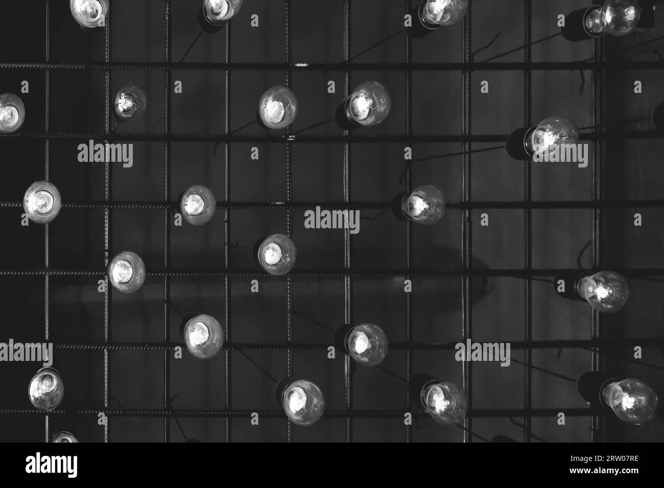 Un groupe de beaucoup d'ampoules blanches élément intérieur de plafond fond sombre abstrait. Banque D'Images