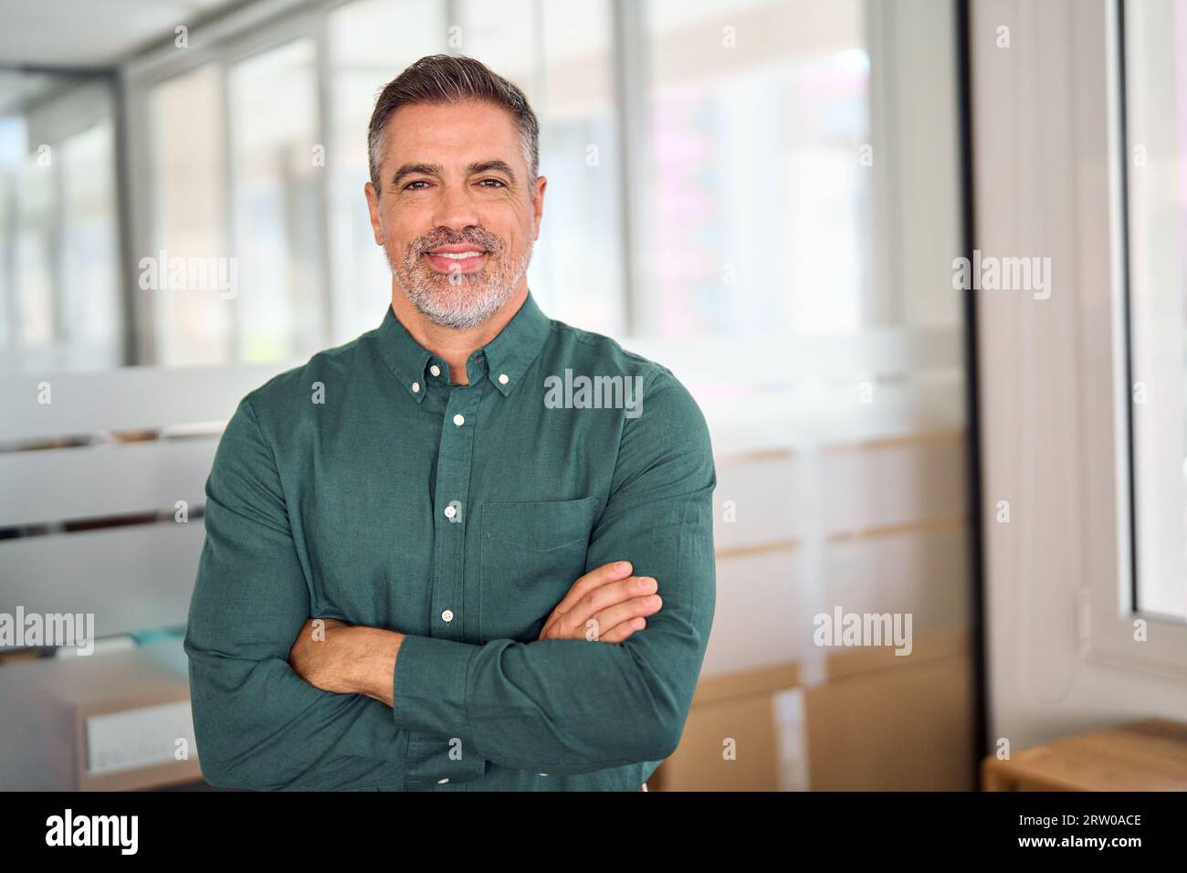 Souriant 40 ans homme d'affaires d'âge moyen debout dans le bureau, portrait. Banque D'Images